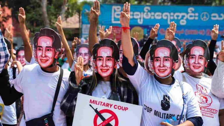 Protesters wearing masks depicting ousted leader Aung San Suu Kyi, flash three-finger salutes as they take part in a protest against the military coup in Yangon, Myanmar. (Image: Reuters)